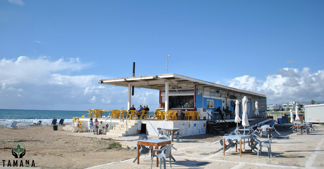 cafe on the beach with blue sky and white cotton candy clouds