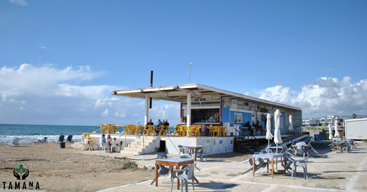 cafe on the beach with blue sky and white cotton candy clouds