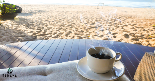 black coffee in white cup on the beach