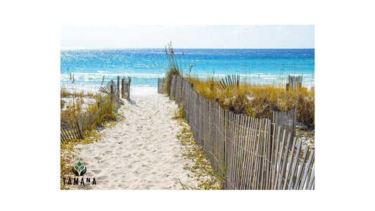 walkway on the sand beach leading out to the blue water. Sun glisterning